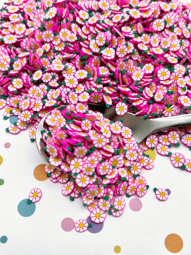 a pile of pink and white flowers next to a pair of scissors