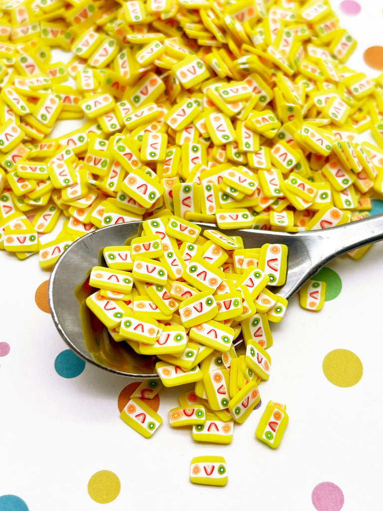 a spoon full of yellow letters sitting on top of a table