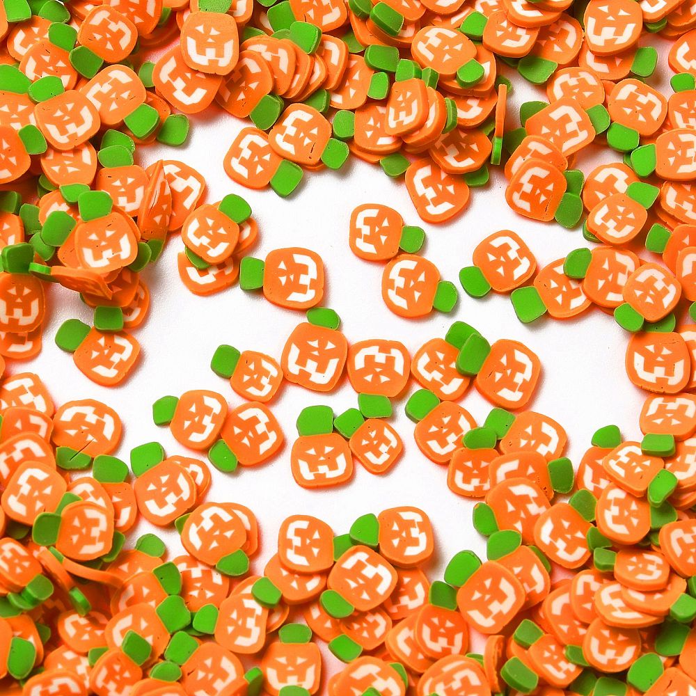 a pile of orange and green buttons on a white surface