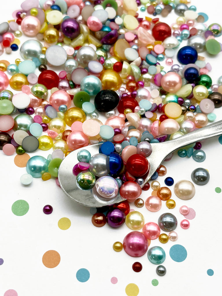 a spoon filled with lots of different colored pearls