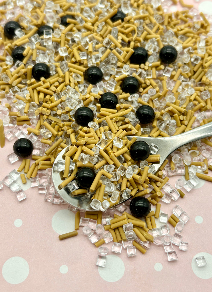 a spoon full of yellow and black sprinkles