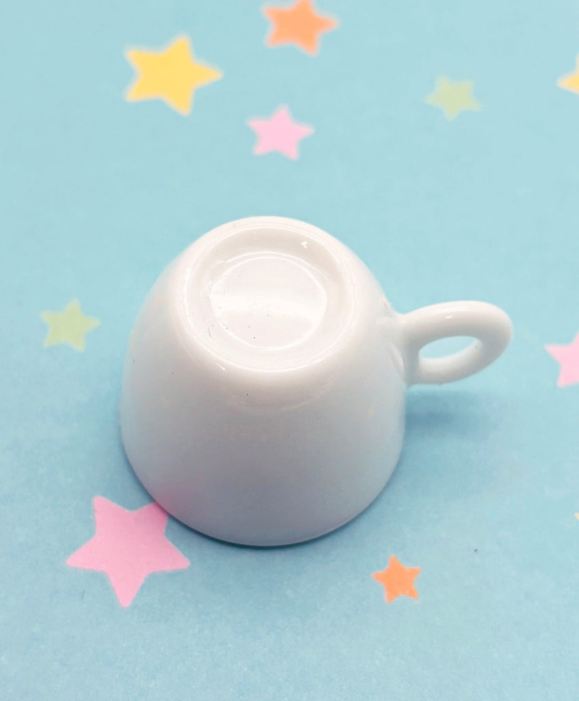 a white tea pot sitting on top of a blue table