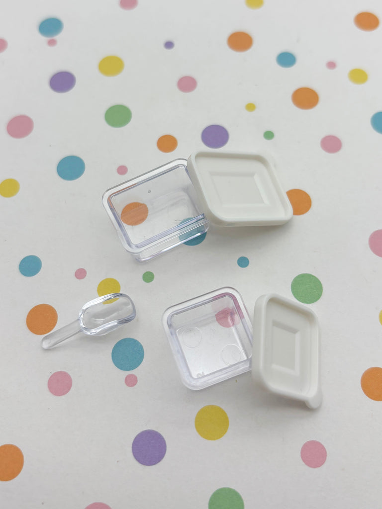 two clear plastic containers with lids, placed on a surface with colorful polka dots.