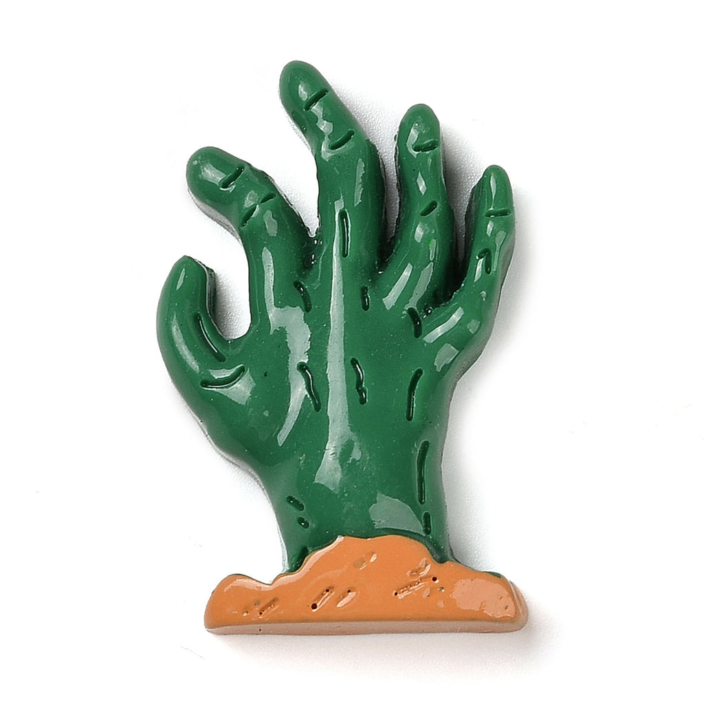 A green, claw-like figurine with a brown base, resembling a zombie hand or a cactus-like object.