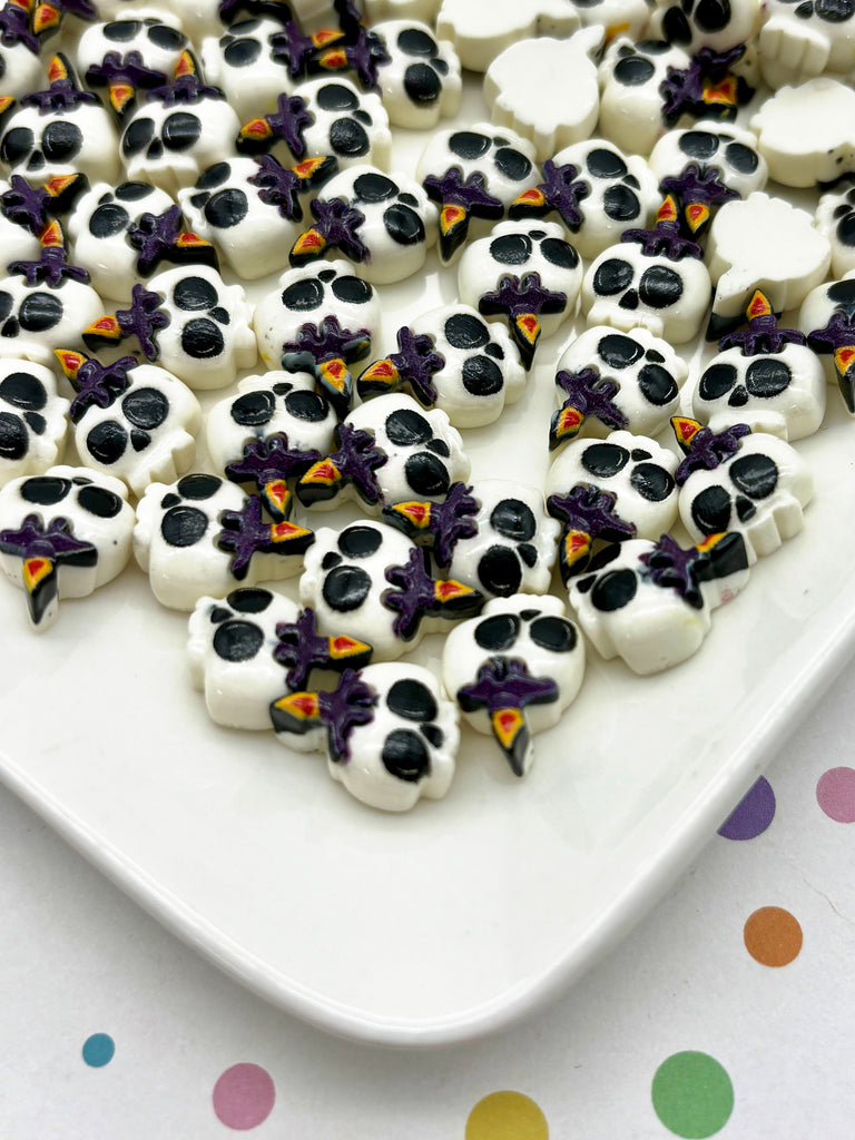 a plate of decorated sugar skulls on a polka dot tablecloth