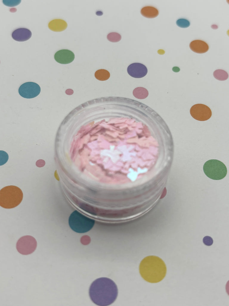 a small jar of pink glitter sitting on top of a table