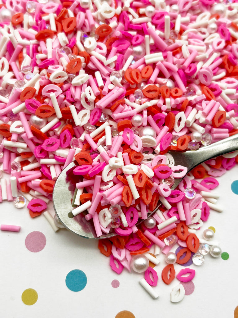 a spoon full of pink and white sprinkles