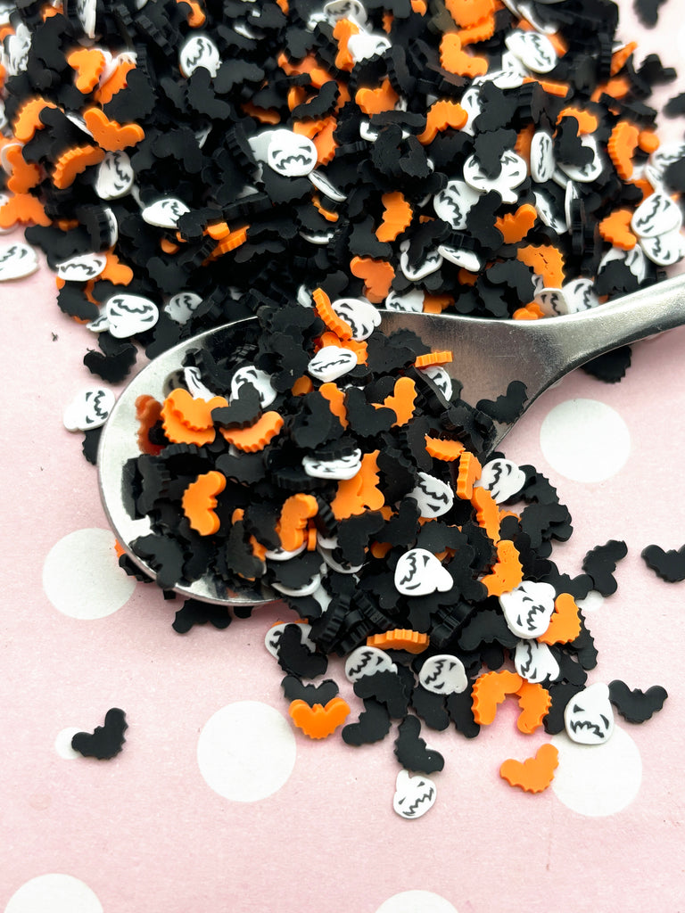 a spoon full of black and orange sprinkles