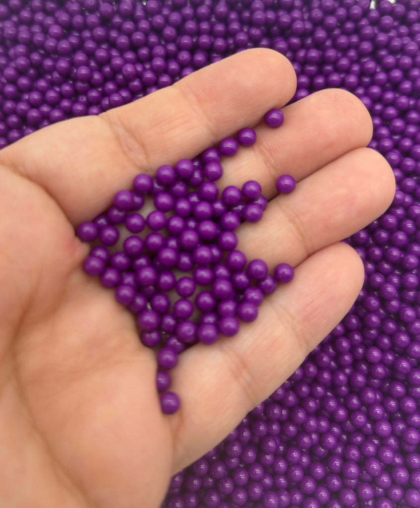 a hand holding a bunch of purple beads