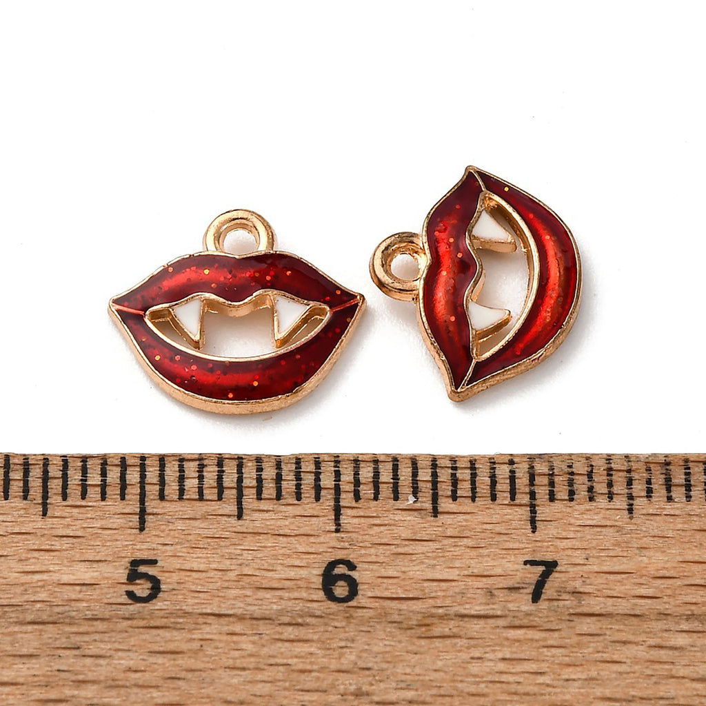 two red enamel charms with gold accents, placed above a ruler for size comparison.