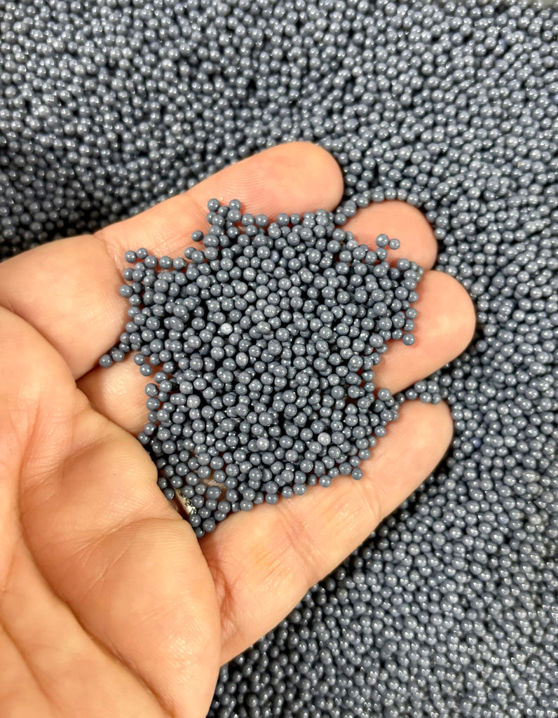 a person holding a small amount of blue beads