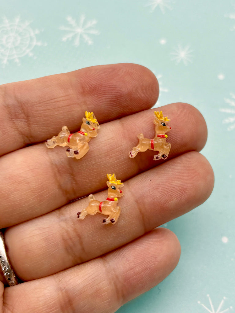 a person is holding three tiny toy horses