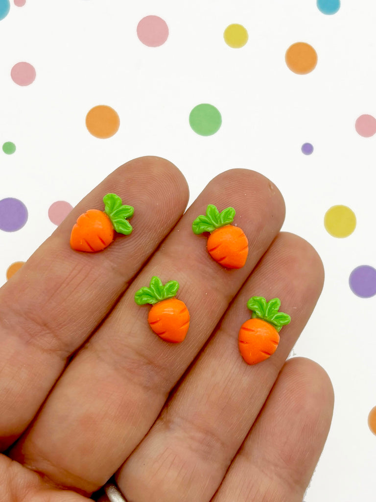 a hand holding three tiny carrots on it's fingers