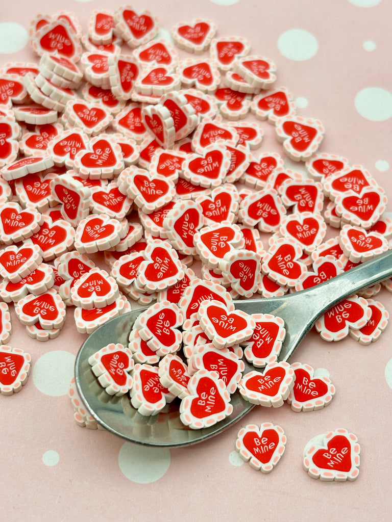 a spoon full of heart shaped cookies on a table