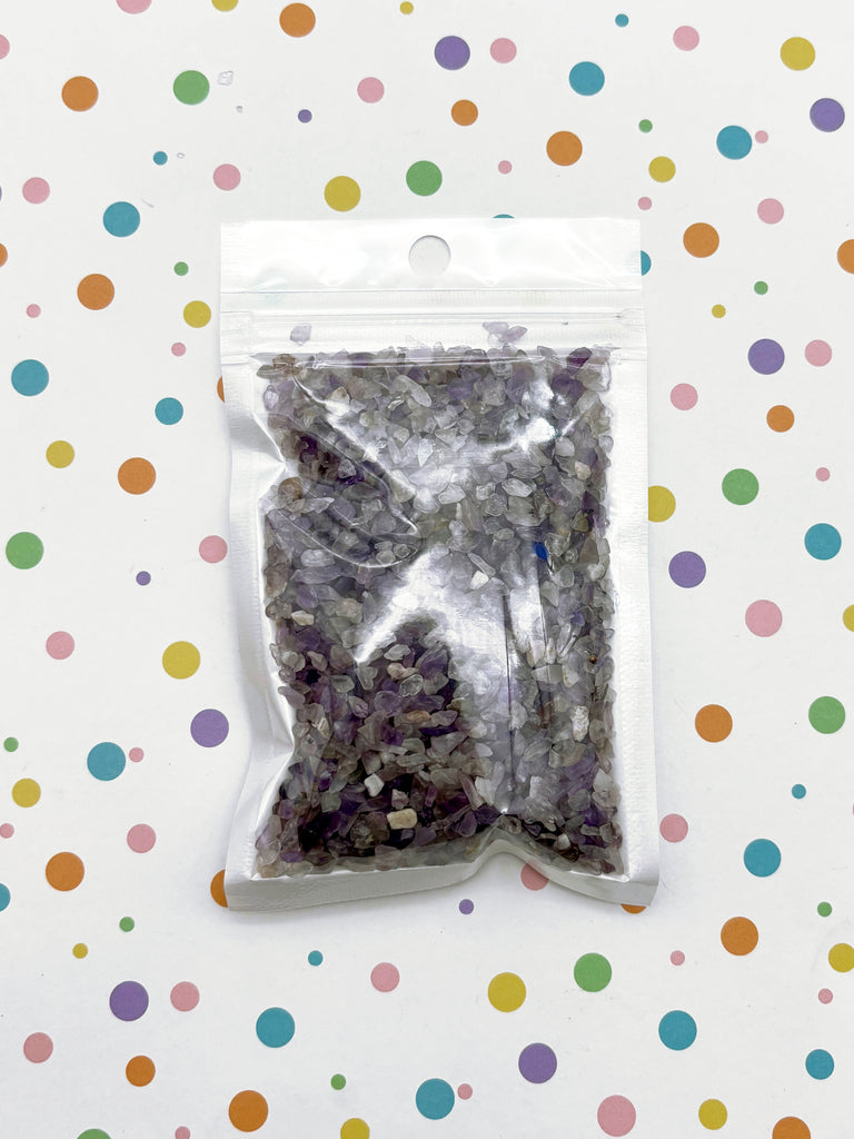 a bag of purple and white confetti in front of a polka dot background