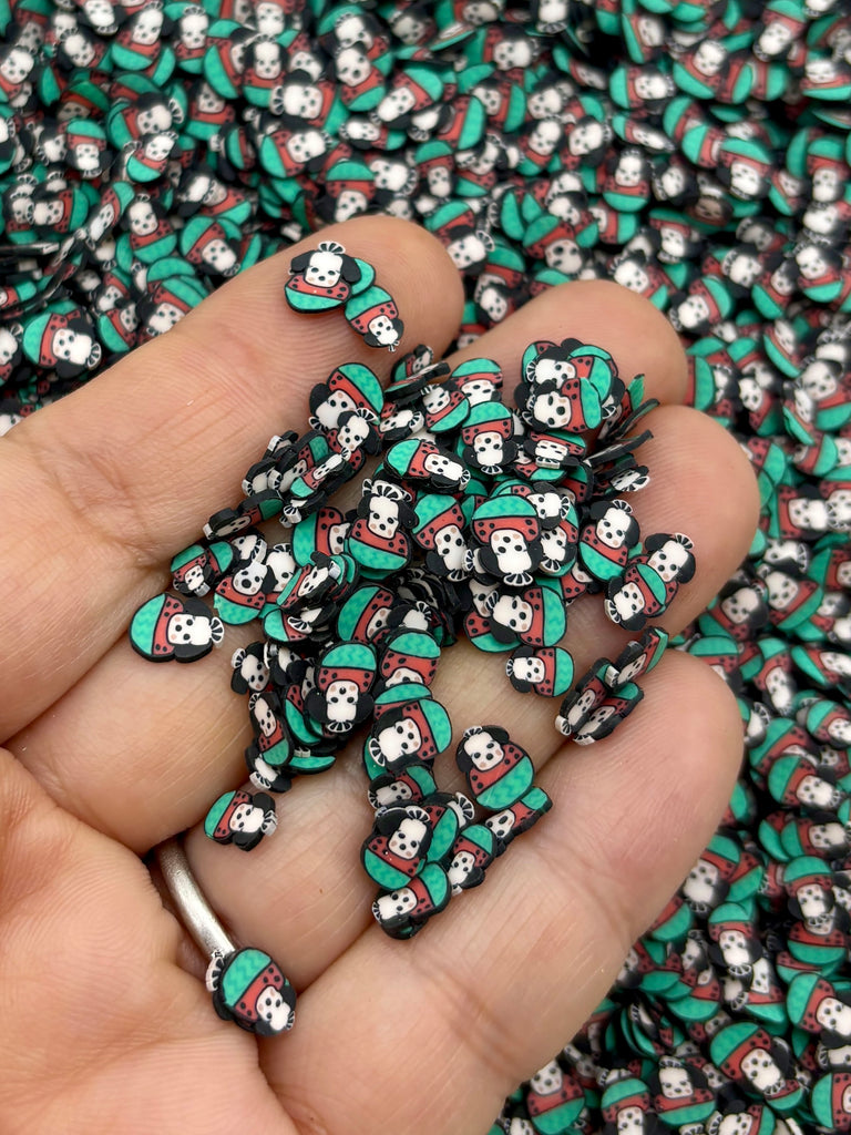 a hand holding a pile of green and black skulls