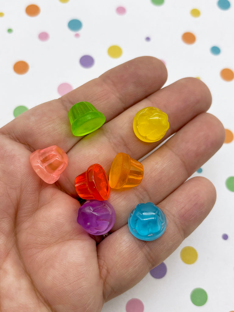 A hand holding a collection of colorful, plastic-like candies against a background with polka dots.