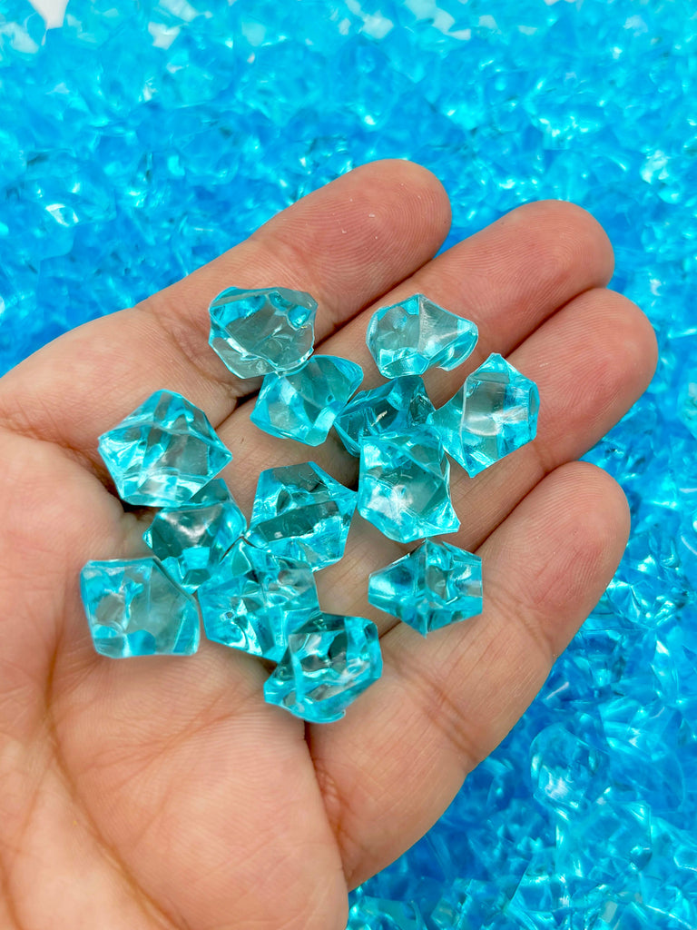a hand holding a bunch of blue crystals