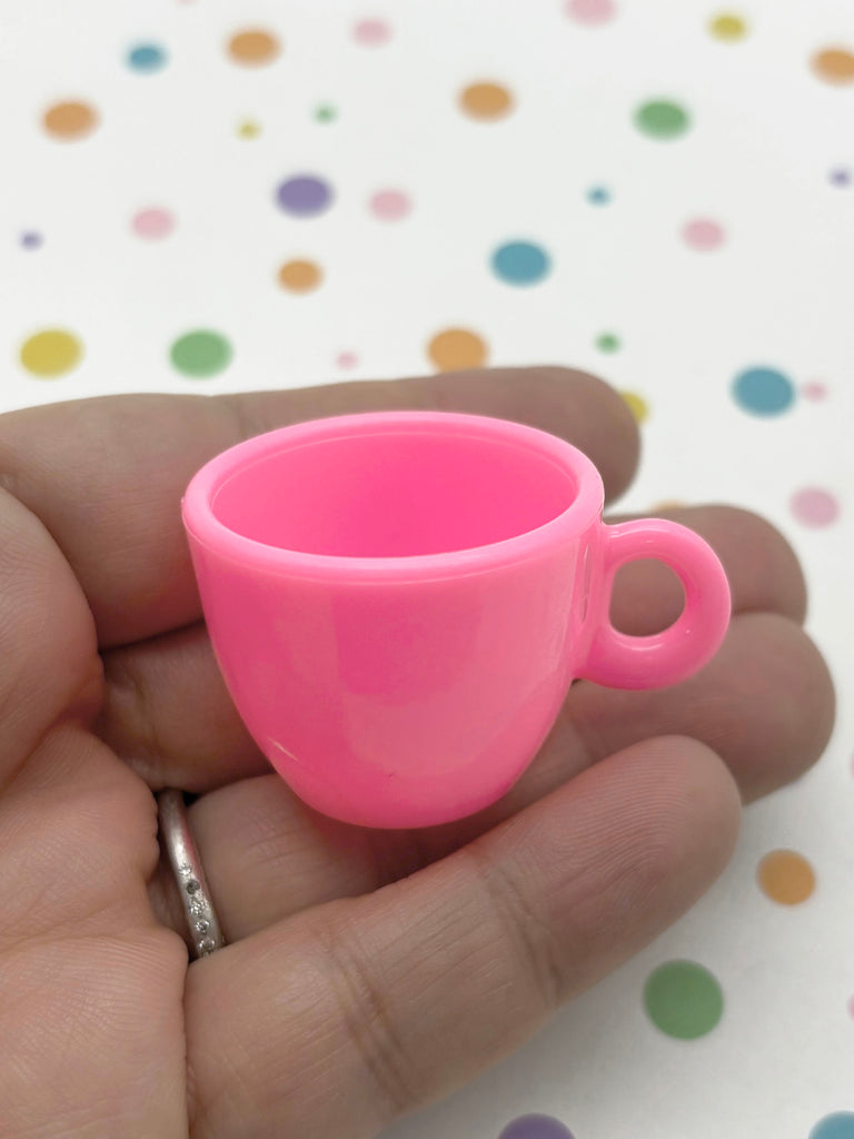 a hand holding a pink cup in it's palm