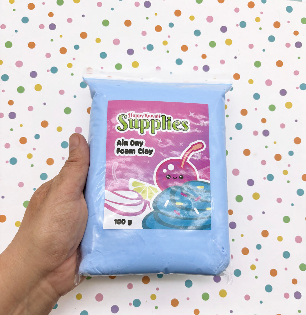 A hand is holding a bag of air dry foam clay with a colorful label featuring a cartoon character.