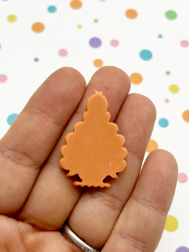 a hand holding a small plastic christmas tree ornament