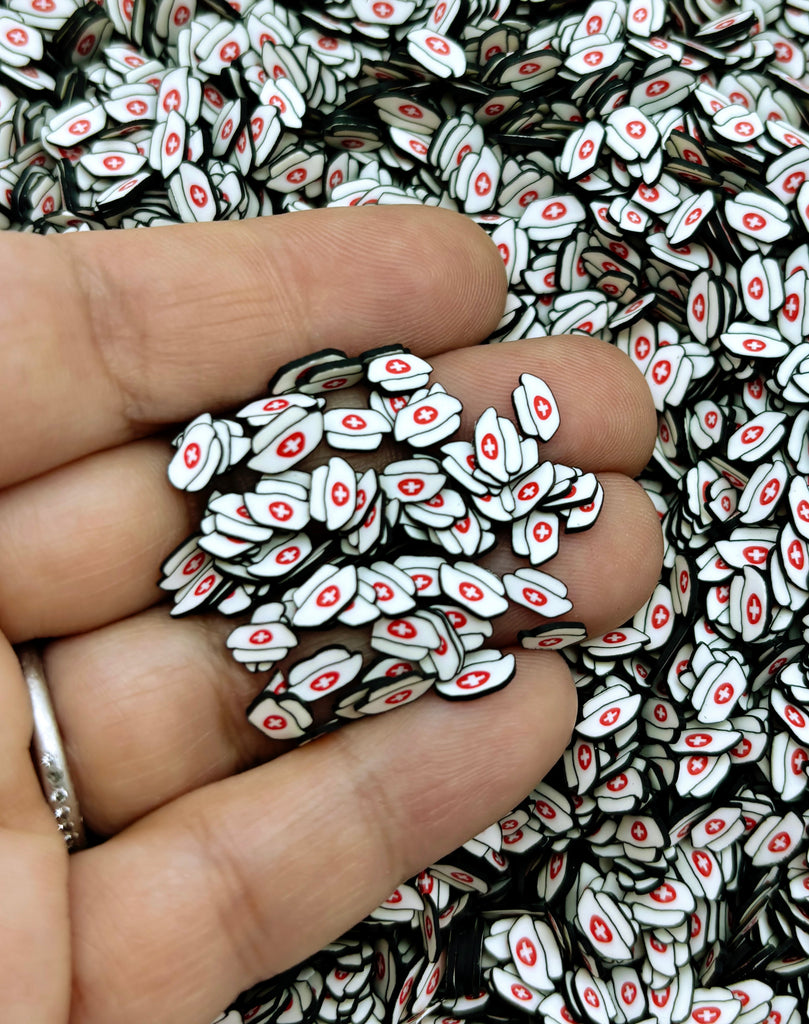 a hand holding a pile of small white and red buttons