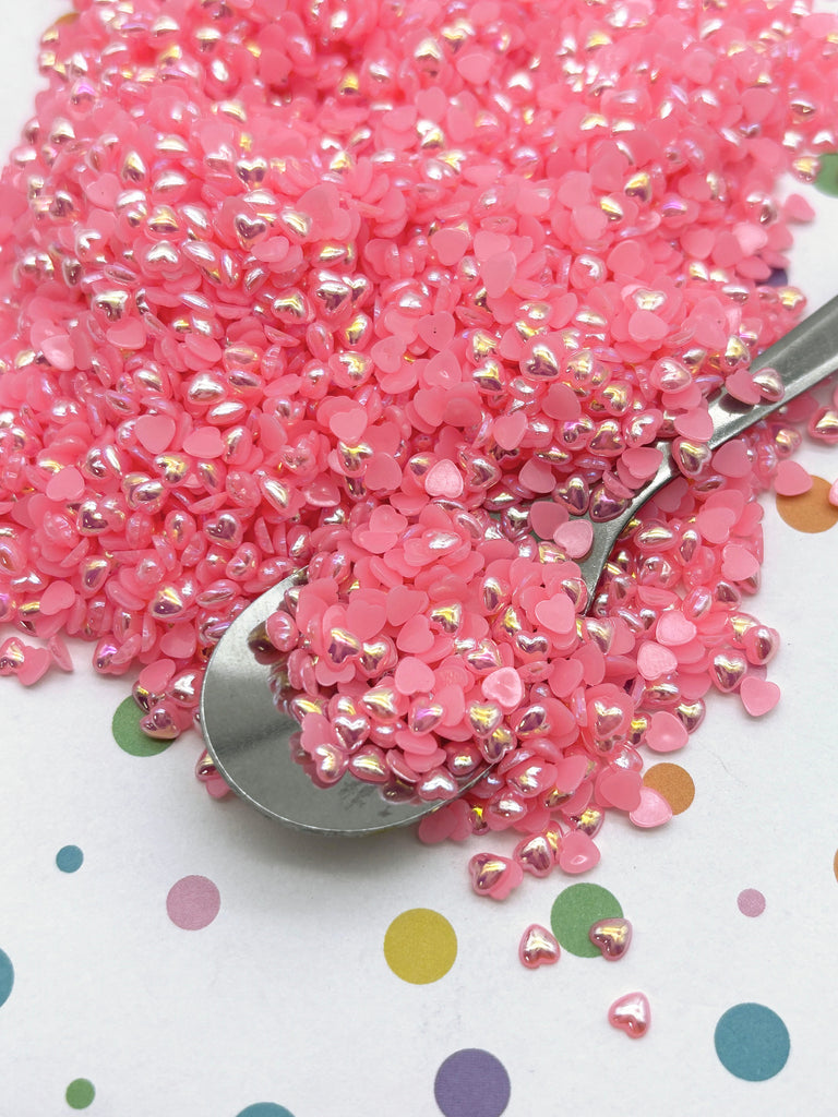 a scoop of pink sprinkles sitting on top of a table