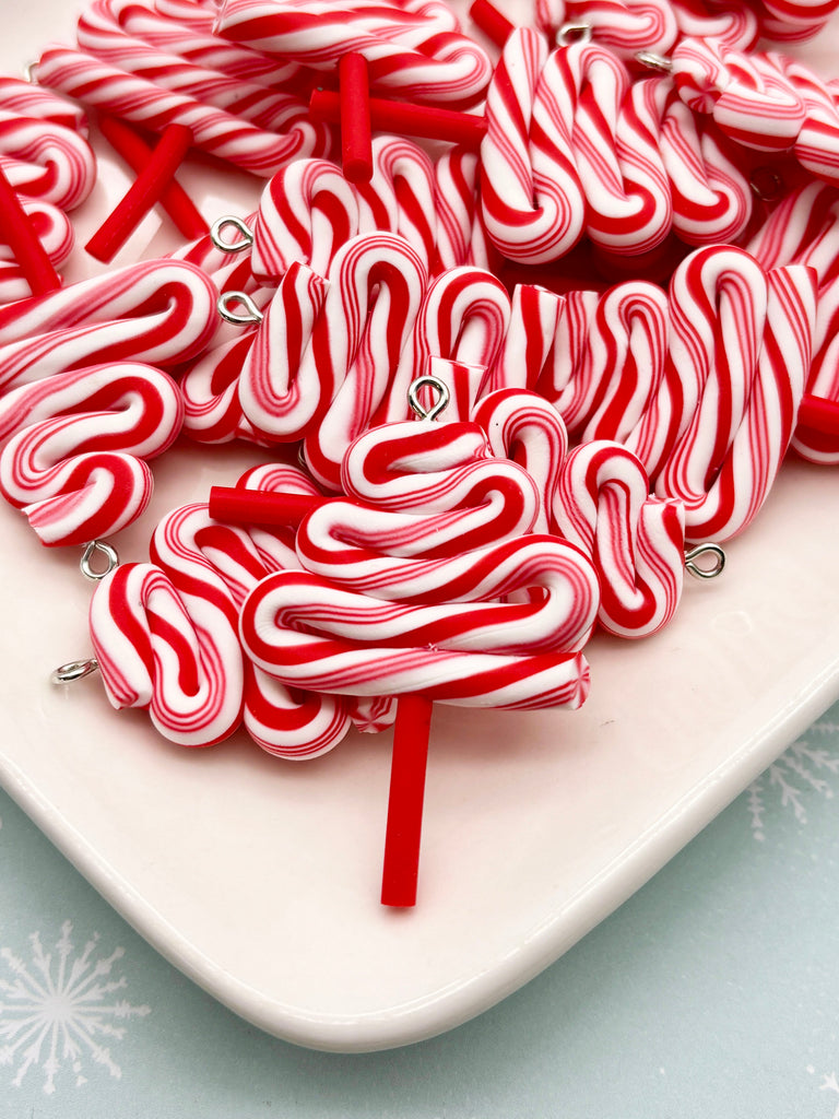 a white plate filled with numerous red and white striped candy canes, creating a visually appealing and festive display.