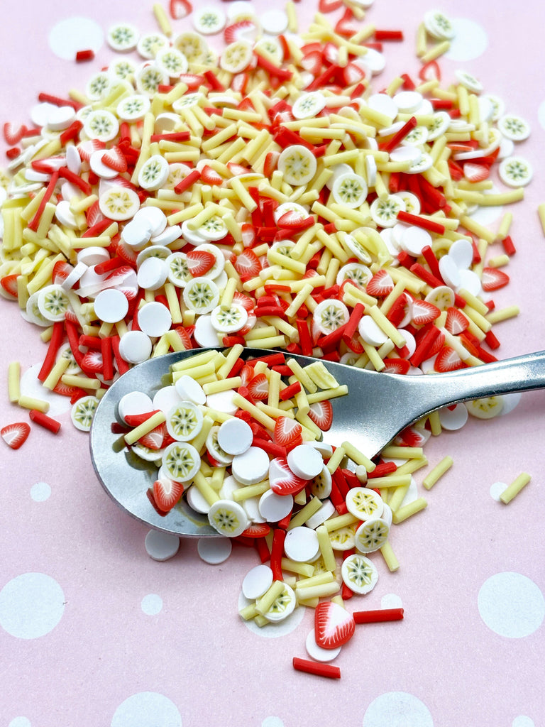 a spoon full of buttons on a pink surface