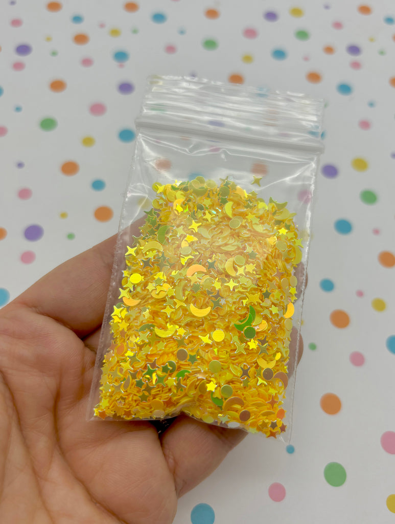 a hand holding a bag of yellow confetti