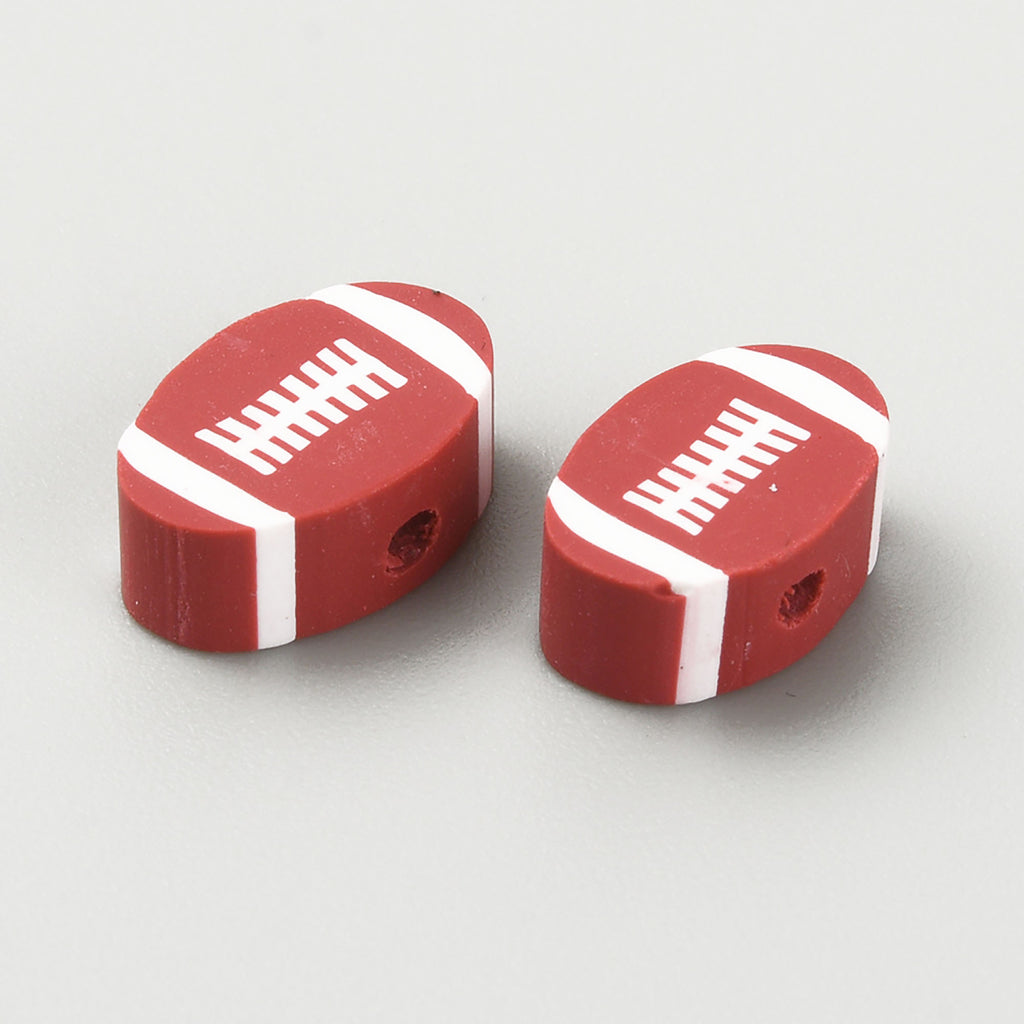 Two red and white football-shaped erasers are placed on a gray surface.