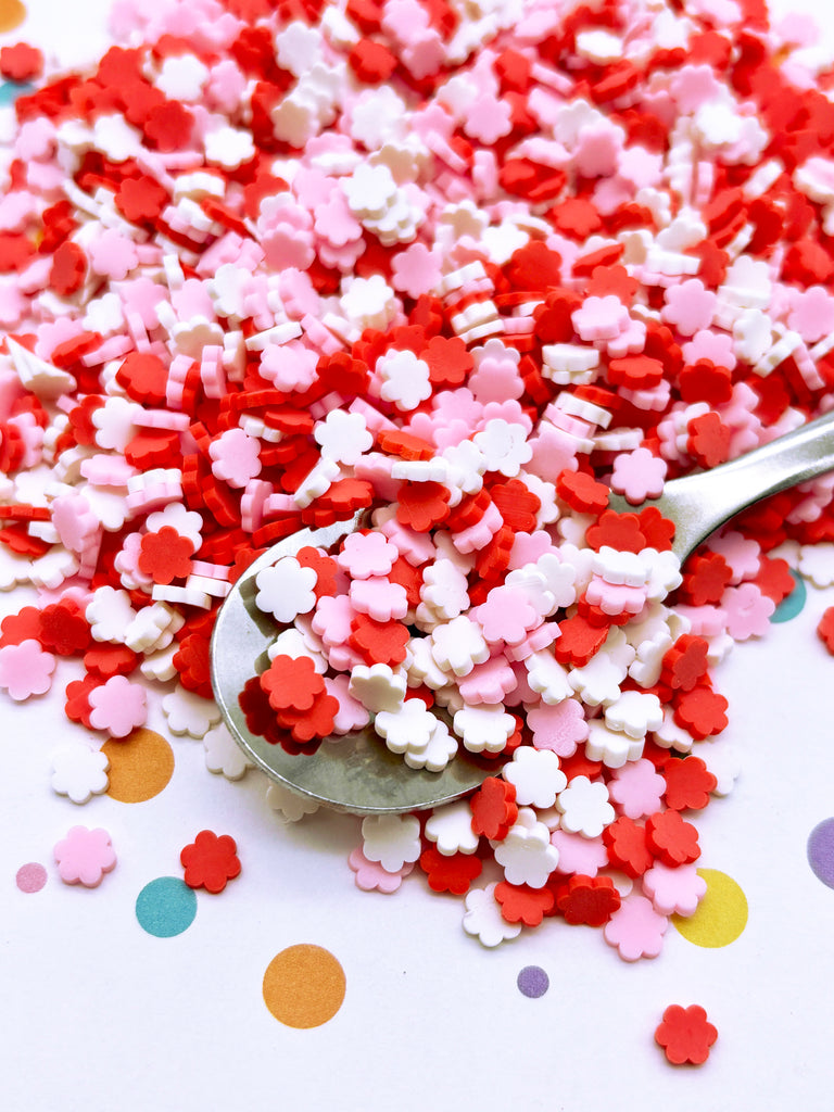 a spoon full of red and white sprinkles