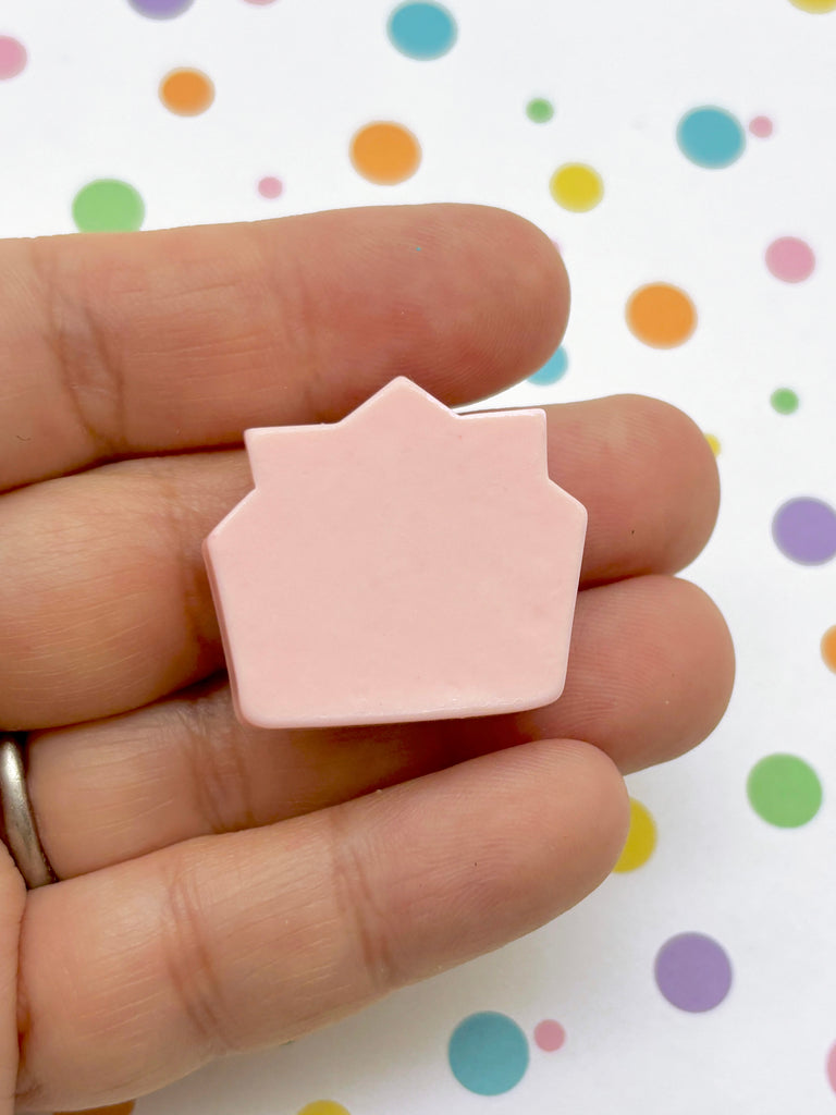 a person holding a small pink object in their hand