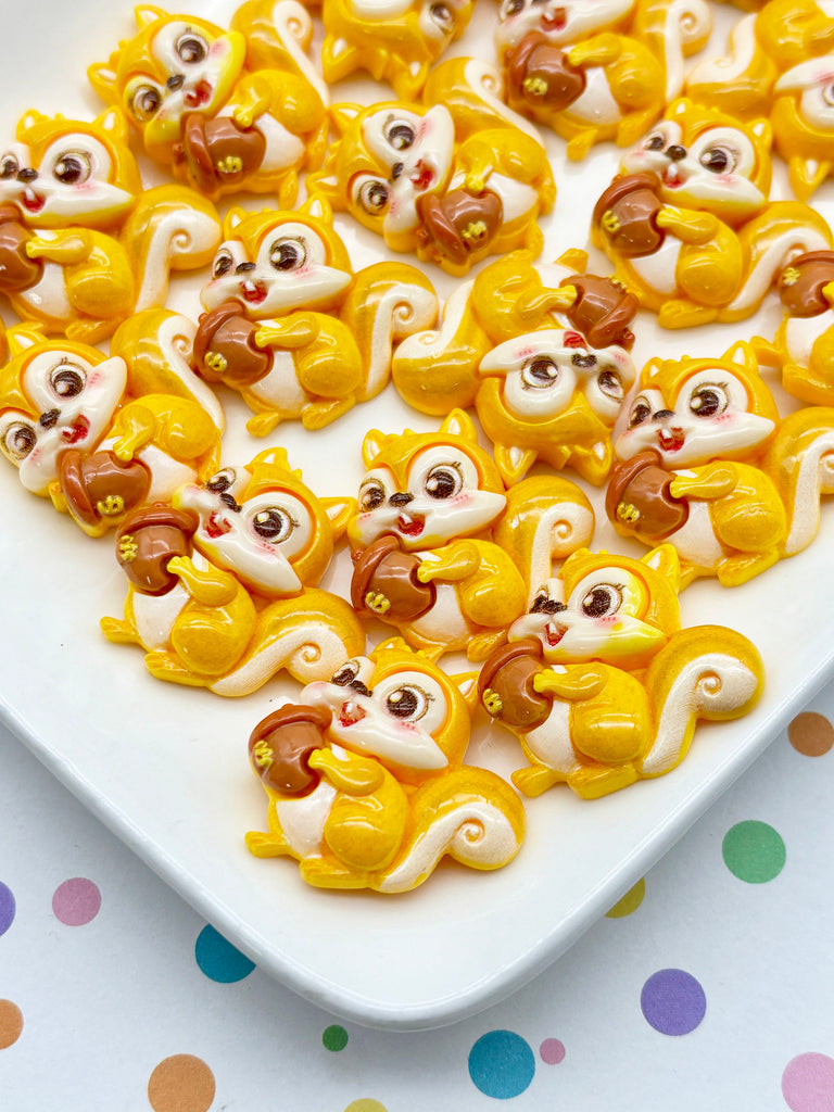 a collection of small, colorful figurines of squirrels arranged on a white surface.