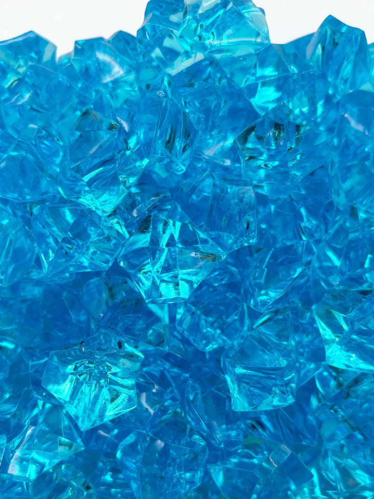 a pile of blue glass cubes sitting on top of a table