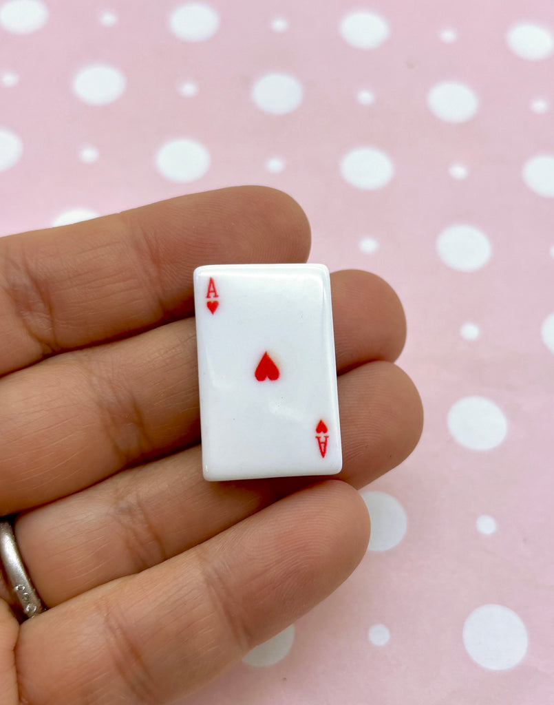 a hand holding a tiny playing card ring