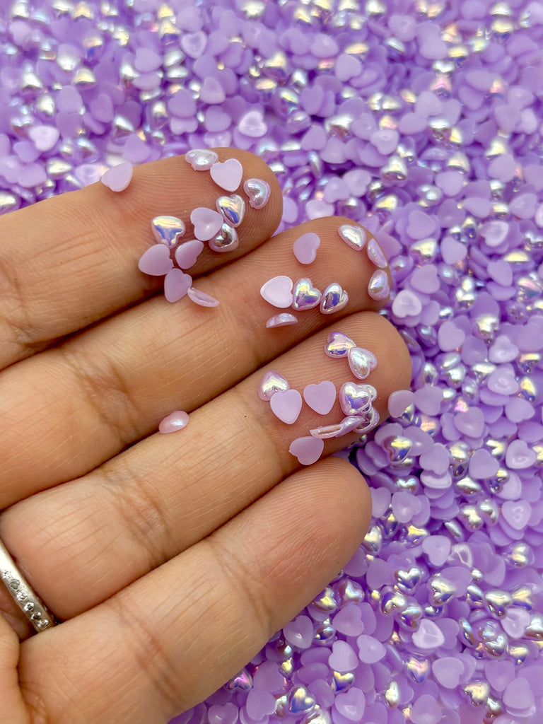 a hand with pink and silver hearts on it