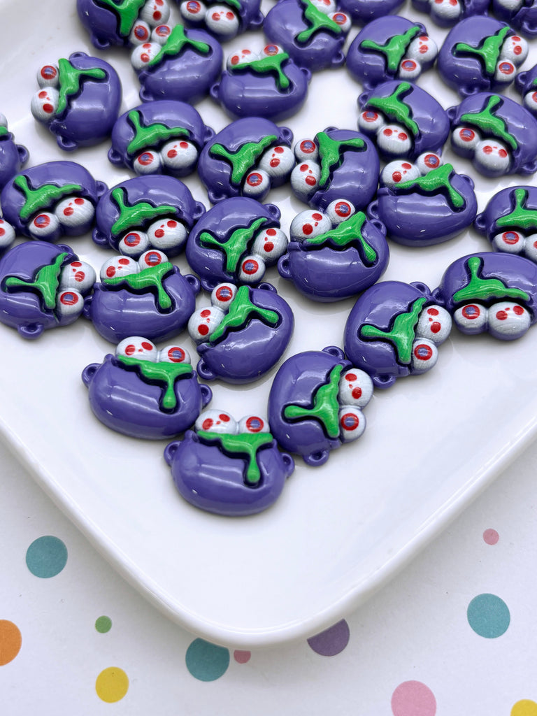 a white plate topped with purple and green decorated cookies