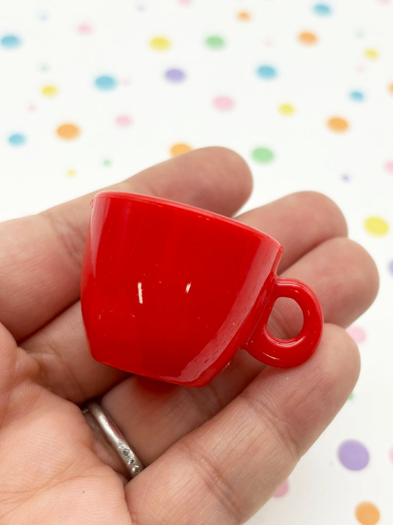 a small red coffee cup in a persons hand