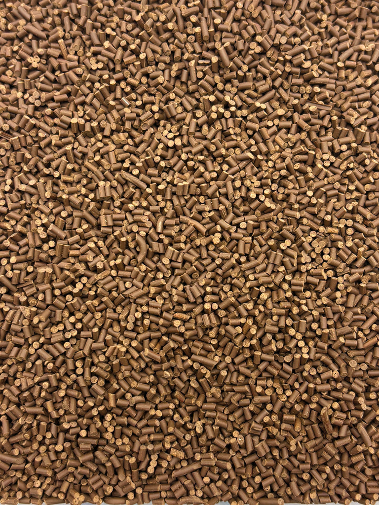 The image is a close-up of a pile of small, brown objects, possibly nuts or seeds, scattered together.