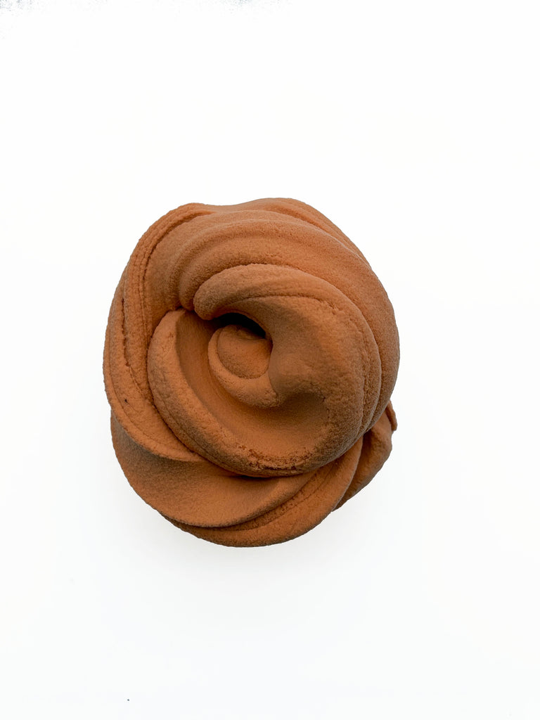 A brown, twisted, and coiled object resembling a piece of chocolate or a similar confection.
