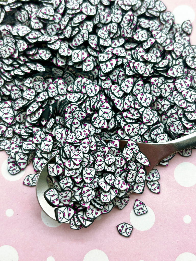 a pile of black and white hearts next to a spoon