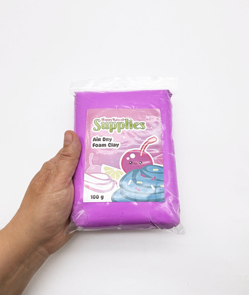 A hand is holding a package of purple foam clay, which is labeled as "HappyKawaii Supplies" and "Air Day Foam Clay".