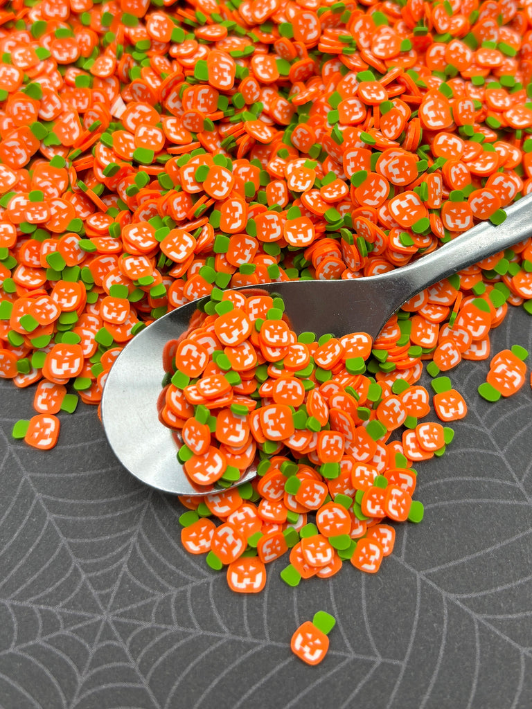 a spoon full of orange and green sprinkles