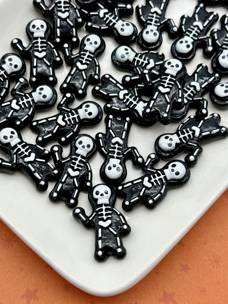 a collection of black and white skeleton-shaped objects arranged on a white surface.