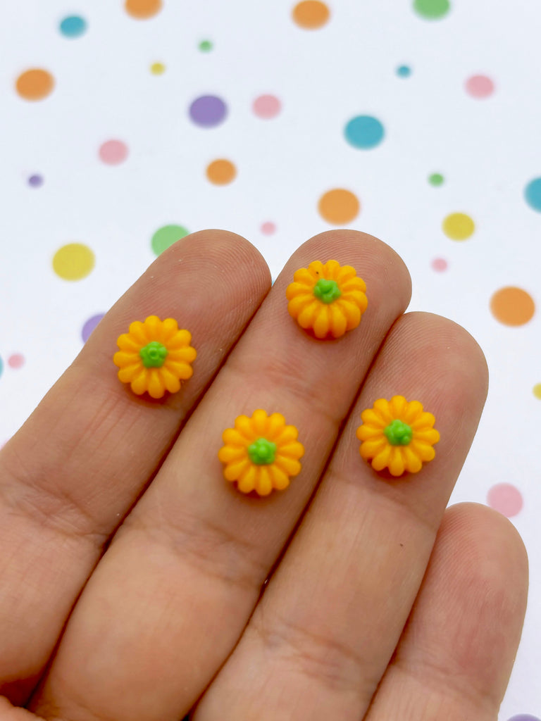 a person's hand holding two tiny yellow flowers