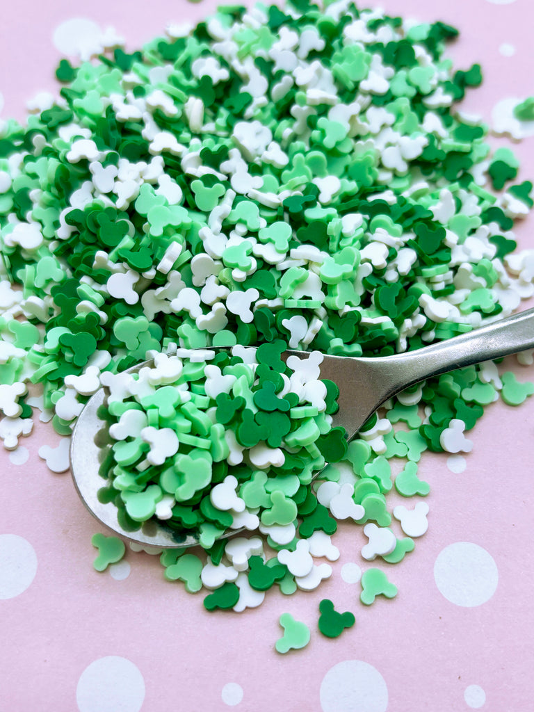 a spoon full of green and white sprinkles