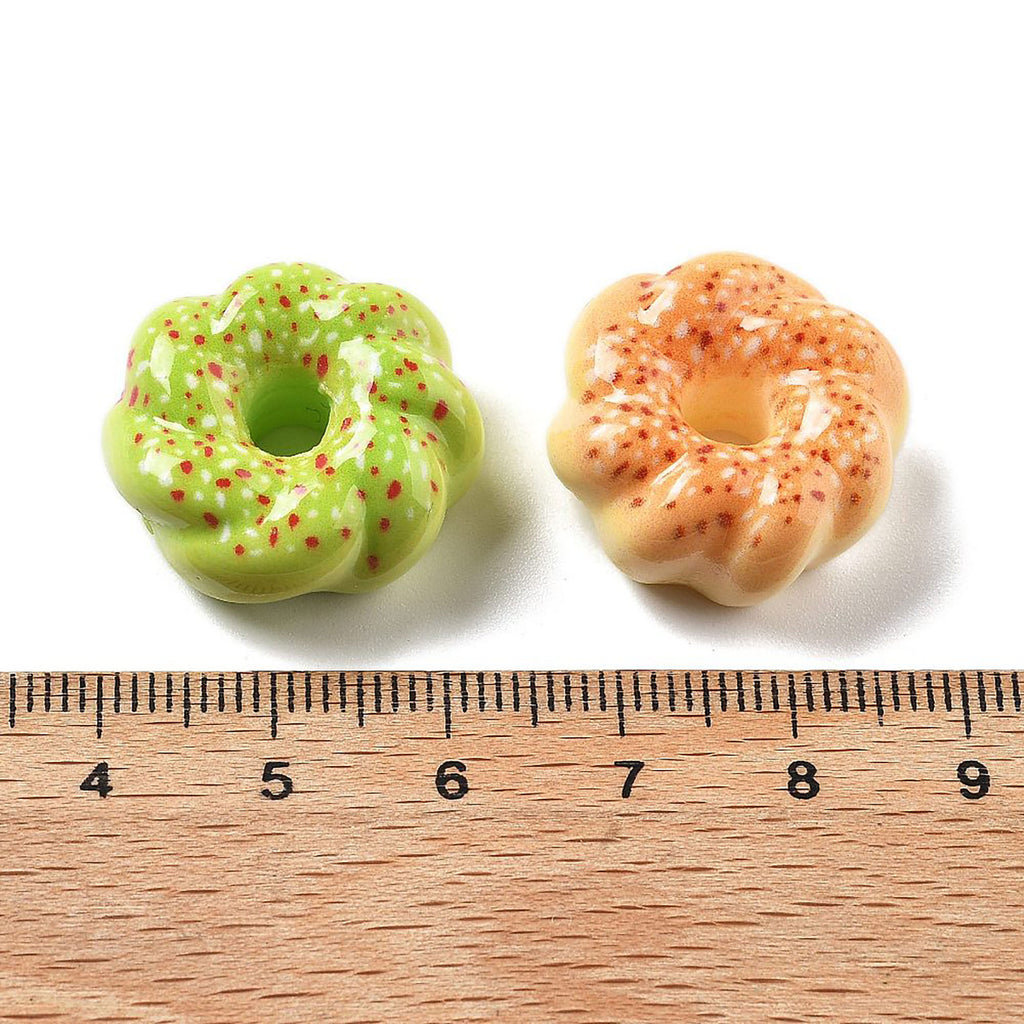 two donuts sitting next to a ruler