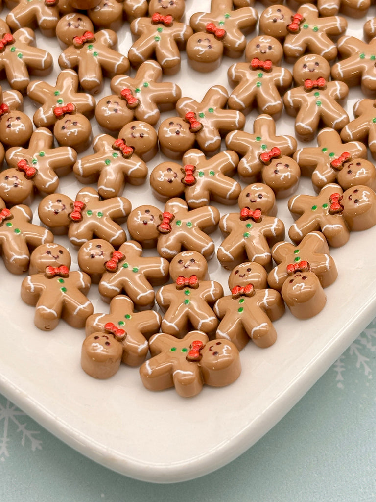 a large number of brown gingerbread man-shaped candies arranged on a white plate.
