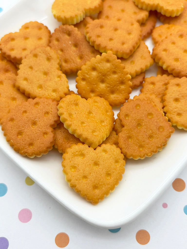 A white plate filled with heart-shaped crackers is placed on a table with colorful polka dots.